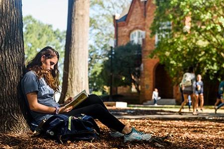 a student works on her laptop beneath denny chimes